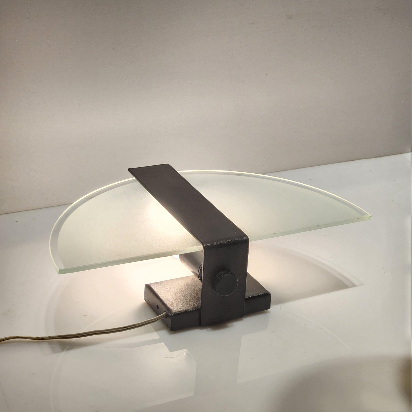 Wall lamp with a half circle frosted glass and black metal stripe in the middle. 
Width 29 cm. Height 16 cm. - BOTTOM -